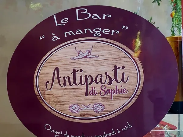 La porte du Bar à manger, plaque ovale en bois et guirlandes de piments